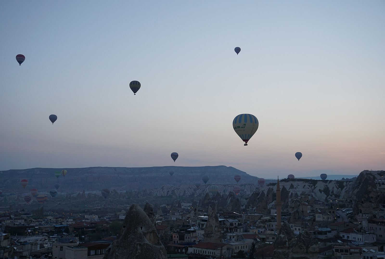 Balony nad kominami skalnymi w porannym świetle w okolicy Göreme