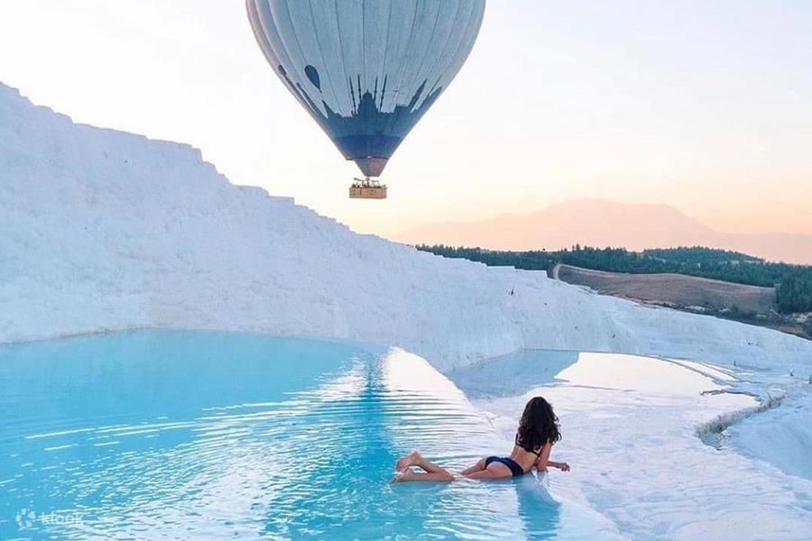 Balon nad białymi trawertynami Pamukkale o świcie