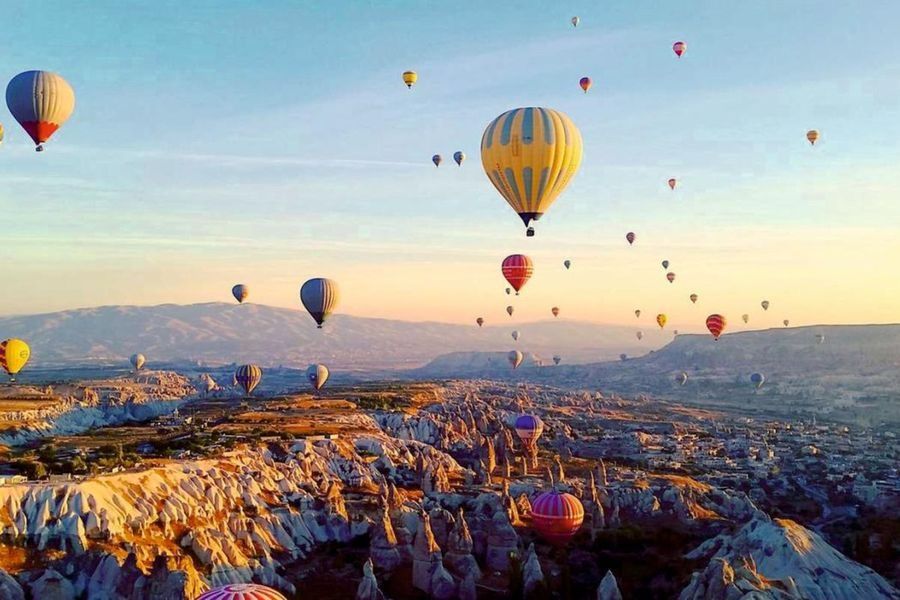 Balon na ogrzane powietrze unoszący się nad doliną w Kapadocji o świcie