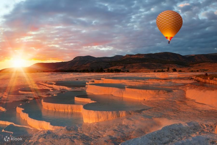 Balon na ogrzane powietrze nad białymi tarasami trawertynowymi Pamukkale