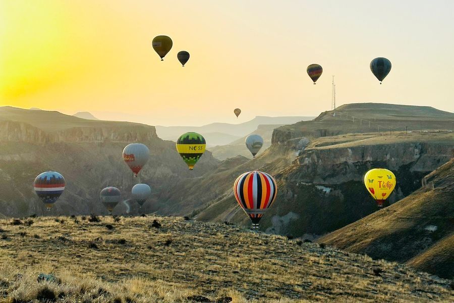 Kolorowe balony nad Doliną Soğanlı w Kapadocji o wschodzie słońca